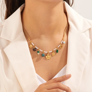 Golden multi-element necklace with sunflower and star pendants worn by a model