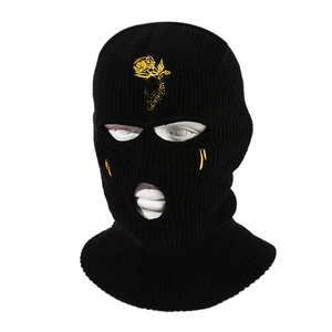 Black 3-hole knitted balaclava with yellow rose embroidery on a mannequin head