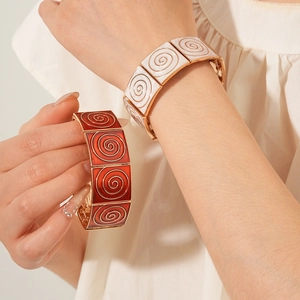 Detail of vintage enamel square link bracelet featuring red and white spiral patterns