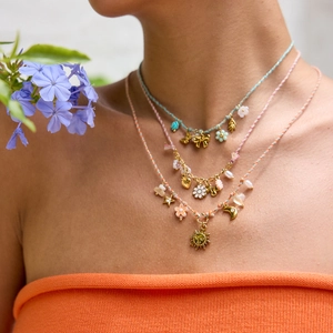 Close-up of bohemian layered cord necklace with gold sun, moon and star pendants