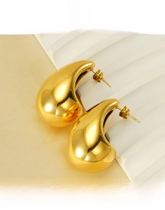 Macro shot of polished gold-plated teardrop earrings made of premium titanium steel