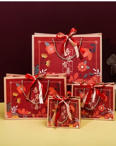 Close-up of Chinese wedding gift bags with elegant calligraphy and ribbon bows