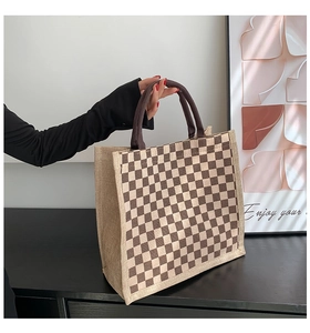 Close-up of linen tote bag with brown checkerboard pattern and thick woven handles