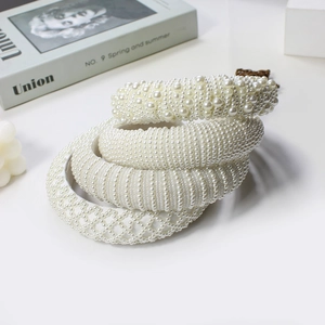 Elegant set of 4 white pearl padded headbands for women on minimalist aesthetic background