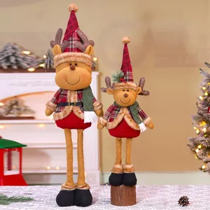 Detail of plush Christmas reindeer dolls in red plaid outfits within a cozy festive home