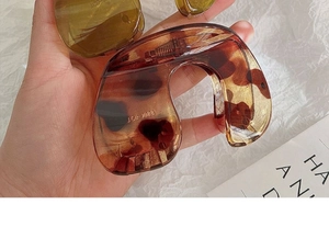 Close-up of a large amber tortoiseshell hair claw clip with detailed resin texture