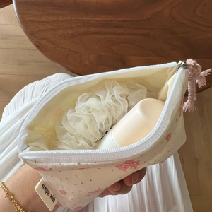 Detailed view of floral cotton storage pouch featuring pink tassel and zipper closure