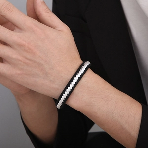Detail of hand-woven black and white cord bracelet with magnetic clasp on male wrist
