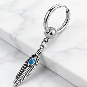 Dettaglio orecchino a piuma argento con pietra turchese blu su base di marmo