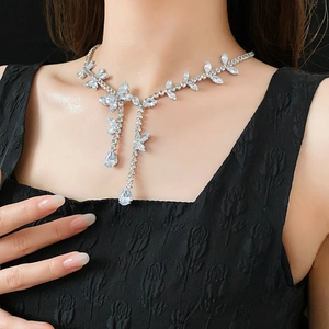 Détail d'un collier argenté avec motif floral et gouttes de zircon sur un mannequin