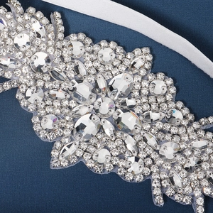 Macro de l'applique florale en cristal strass argenté sur ruban de satin fin