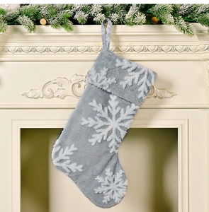 Detailed close-up of a plush gray Christmas stocking with white snowflake pattern hanging