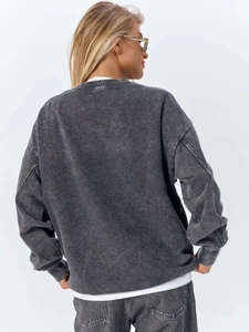 Back view of a loose-fit acid wash dark grey sweatshirt showing the fabric silhouette