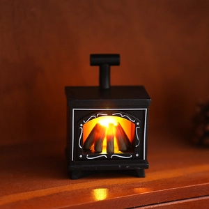 Cozy mini LED fireplace lantern with warm orange glow on dark wooden texture background
