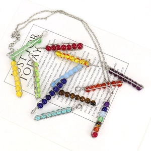 Macro detail of handmade wire-wrapped chakra crystal pendants in various vibrant colors