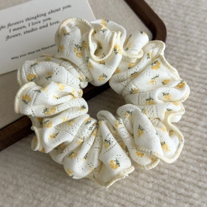 Detail of floral scrunchie with yellow flower pattern and delicate knit texture
