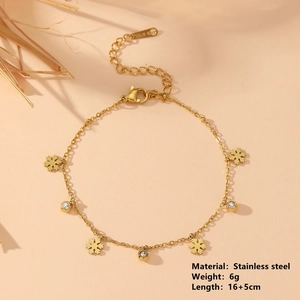 Bracelet flocon de neige en acier inoxydable doré avec trois zircons sur fond beige chaud
