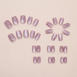 Flat lay of soft purple cat-eye press-on nails in various sizes for different nail widths