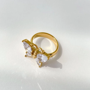 Détail d'une bague papillon dorée avec des pierres étincelantes en zircon cubique