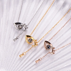 Macro detail of Angel Eye projection necklaces in gold, silver, and rose gold finishes