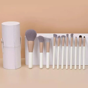 Detail view of 12-piece mini makeup brush set with white cylindrical storage case