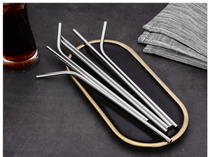 Polished silver stainless steel straight and curved straws on a decorative black tray