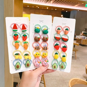Primo piano di elastici per capelli colorati con motivi di frutta e animali a mano
