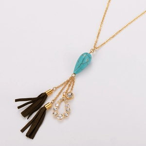 Détail du collier en acier inoxydable avec pendentif turquoise et glands en daim marron vintage