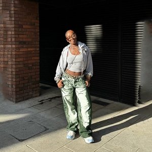 Detailed view of green and white tie-dye wide-leg pants in an outdoor street style setting