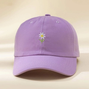 Close-up of embroidered white daisy on a light purple cotton baseball cap for summer