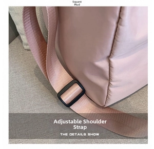 Detail view of the adjustable pink shoulder strap with a matte buckle on the sports bag