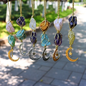 Detail of DIY woven crystal hangers with star and moon charms in natural sunlight