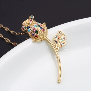 Detail shot of a rose heart pendant with colorful zircon stones on a white ceramic plate