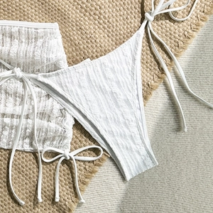 Detaillierte Makroansicht des weißen Bikini-Sets mit Spitzentextur und seitlichen Schnüren