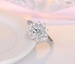 Macro detail of silver heart ring featuring sunflower design with circular cut main stone