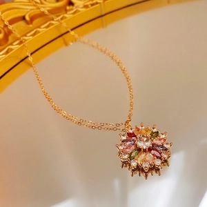 Gold-plated sunflower necklace with colorful zircon stones on a vintage mirror surface