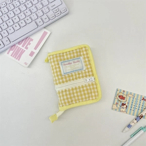 Close-up of a yellow gingham quilted mini binder featuring a heart-patterned fabric texture
