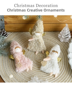 Detail view of plush angel dolls with glitter wings and heart accents on straw mat