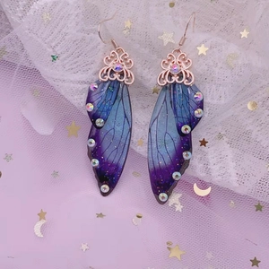 Detailed close-up of blue-purple gradient cicada wing earrings with rose gold hooks