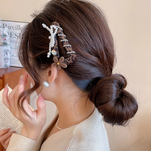 Detail von Leopardenmuster Haarklammer mit Perlen und beflockter Blume in eleganter Frisur