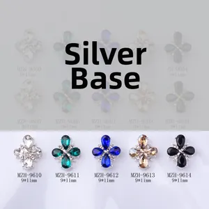 Macro detail of 9x11mm cross flower nail charms with teardrop rhinestones in various colors