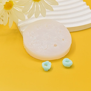 Detailed view of circular silicone donut mold with blue floral fondant pieces