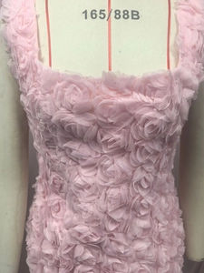 Gros plan sur la texture florale 3D rose et le tulle froissé de la robe courte d'été