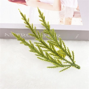 Three-pronged artificial pine needles on a white plush background for Christmas DIY decor