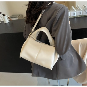 Detail view of white soft leather crossbody bag with stylish shoulder strap and minimalist design
