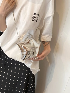 Silver star-shaped acrylic crossbody bag with rhinestone tassel and chain strap on model