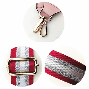 Detail of red and silver striped woven shoulder strap with gold hardware lobster clasps