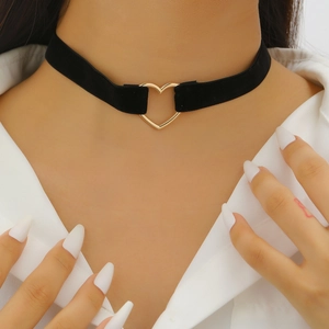 Detail of black velvet choker featuring a gold open heart pendant on model