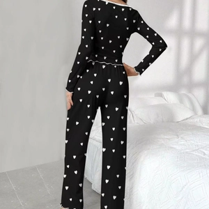 Women black pajama set with white heart print featuring long sleeves and ruffled edges
