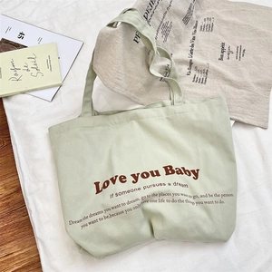 Detailed texture of thick green canvas tote bag with bold Love you Baby typography